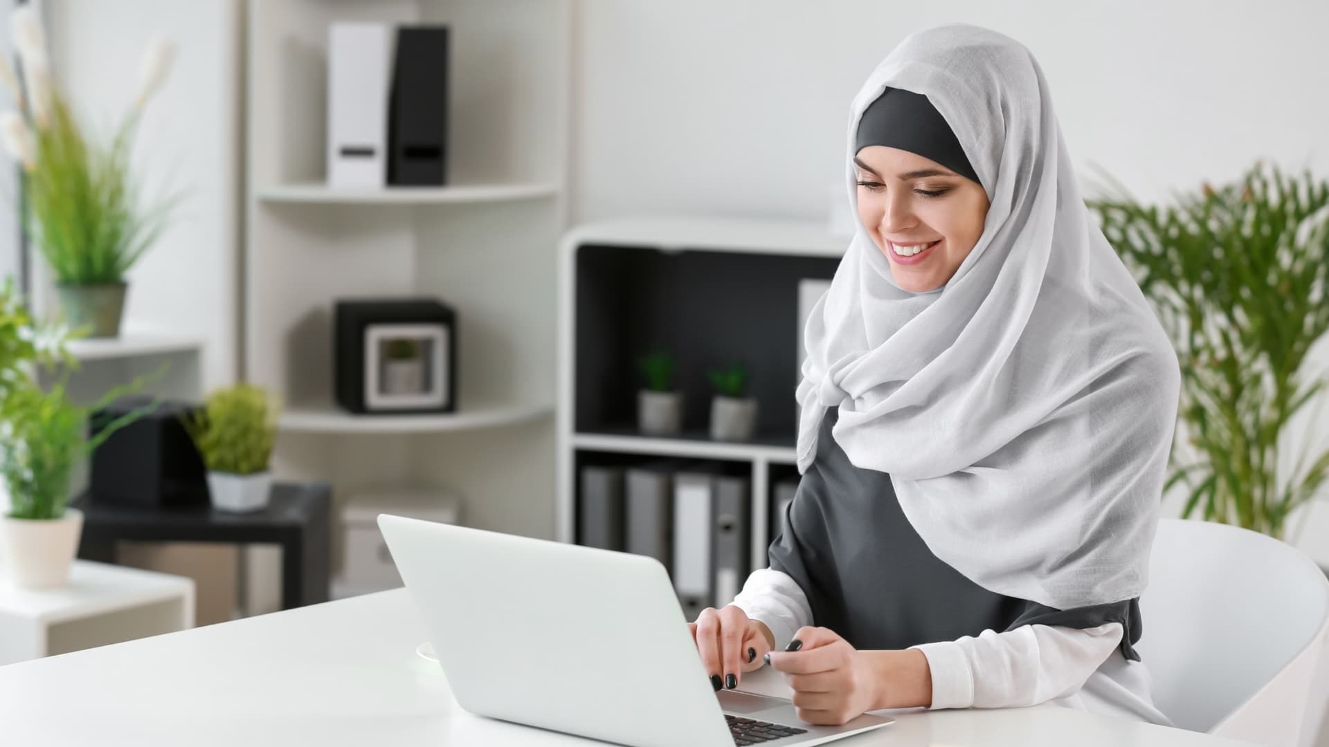 Woman at laptop, adding an email account in Outlook