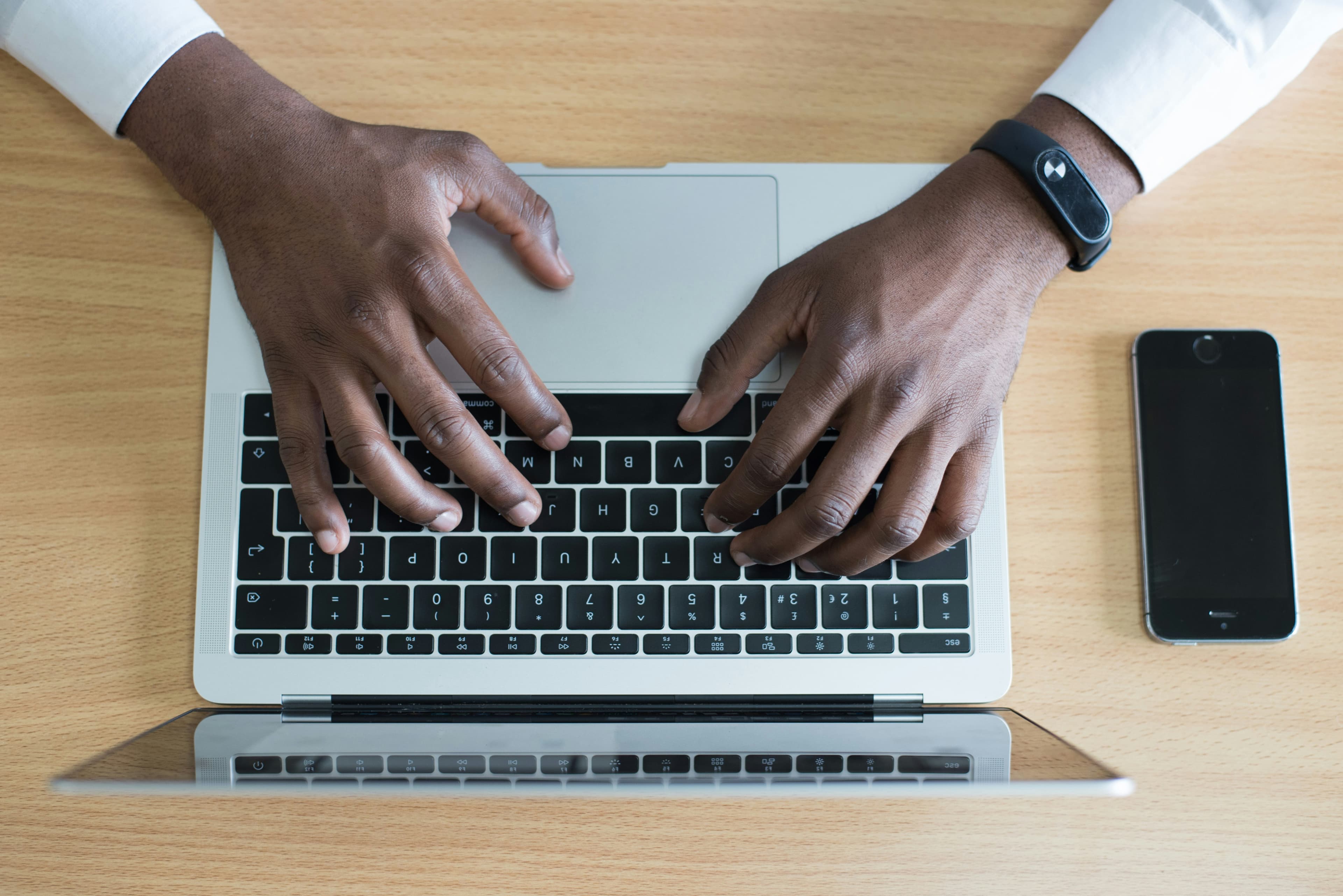 Man typing on laptop keyboard